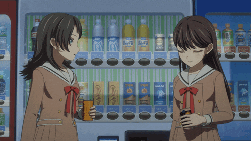 two girls standing in front of a vending machine with coca cola boxes