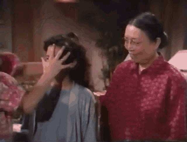 two women are sitting next to each other in a living room .
