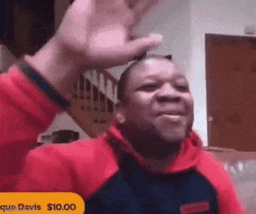 a man in a red hoodie is giving a high five to another man .