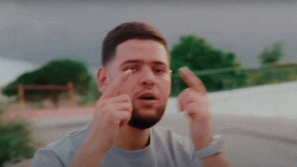 a man with a beard is making a funny face with his hands .