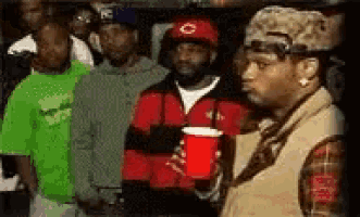 a man is holding a red cup in front of a crowd .