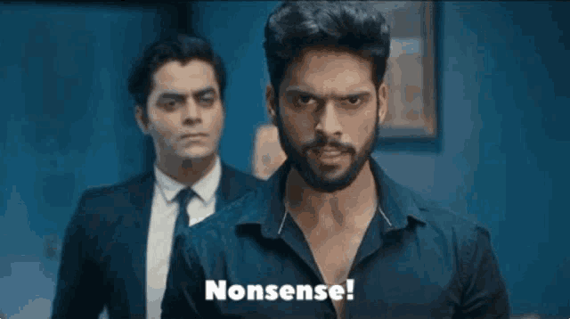 a man with a beard is standing in front of another man and says nonsense