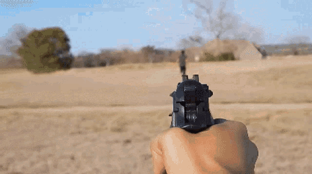 a person is pointing a gun at a field