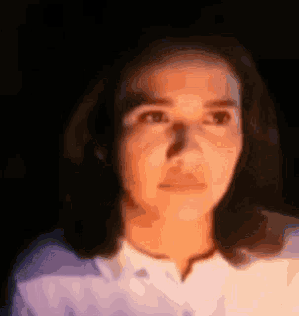 a blurry picture of a woman 's face with a light shining on it