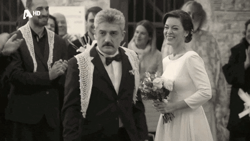 a black and white photo of a bride and groom with a hd logo on the bottom right