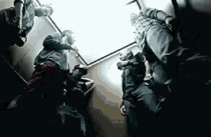 a group of people are standing in an elevator and looking up at the sky .