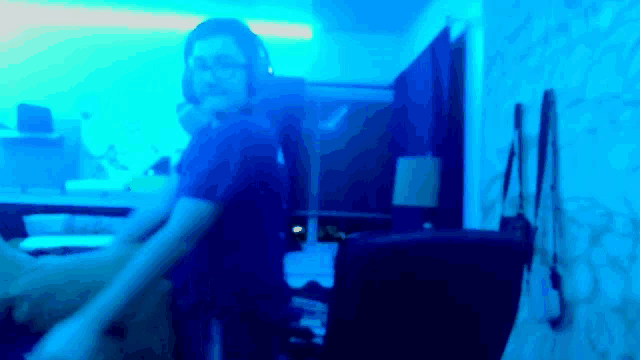a blurry picture of a person wearing headphones in a room with blue lights