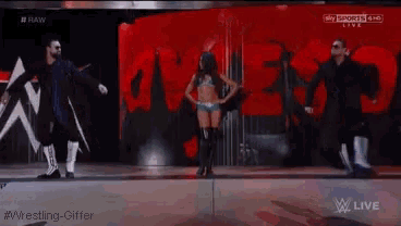 a group of people are dancing on a stage in front of a wall that says raw on it