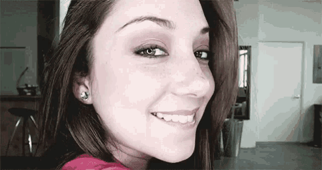 a close up of a woman 's face with a red shirt on