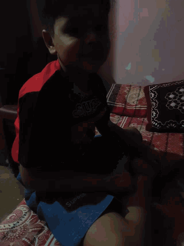 a young boy wearing a shirt that says supreme on it
