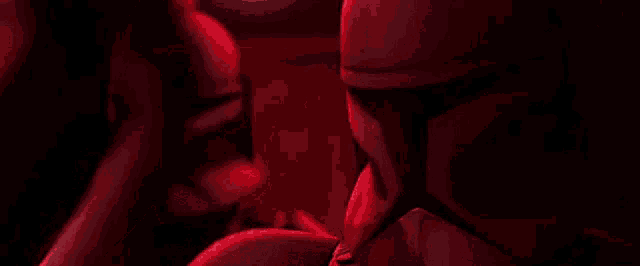 two clone trooper soldiers are standing next to each other in a dark room in a red light .