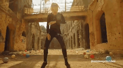 a woman is dancing in front of a bunch of balloons