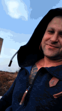 a man wearing a blue jacket with an anchor on the sleeve