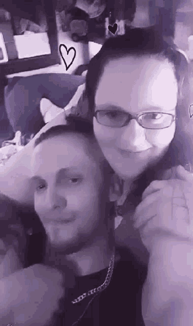 a man and a woman are posing for a picture with a heart drawn in the background