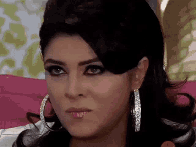 a woman wearing hoop earrings is looking at the camera