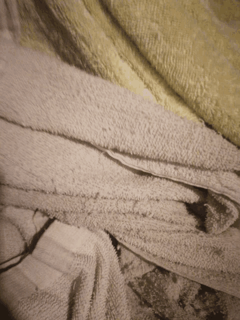 a pile of white towels and yellow towels