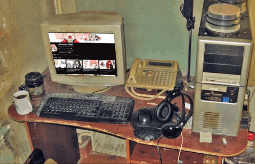 a computer with a screen that says ' tokyo ghoul ' on it sits on a messy desk