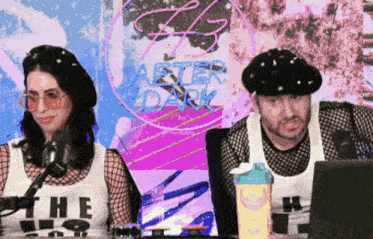 a man and a woman are sitting in front of a sign that says " after dark "