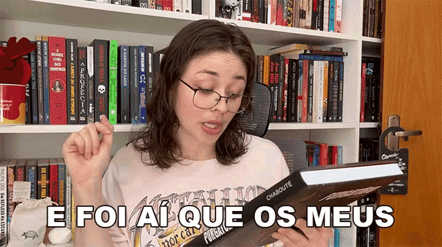 a woman holding a book with the words e foi ai que os meus on it