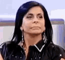 a woman with long black hair is making a funny face .