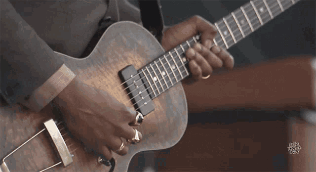 a close up of a person playing a guitar with a logo that says ella radio