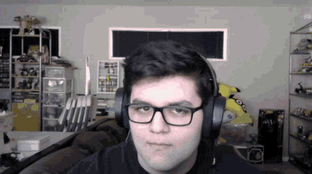 a man wearing glasses and headphones is looking at the camera