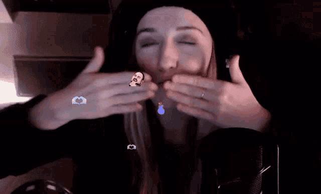 a woman in a black hat is making a funny face with her hands
