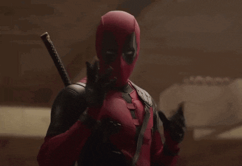 a man in a deadpool costume is holding a sword in his hands .
