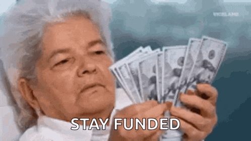 an elderly woman is holding a bunch of money in her hands .