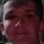 a close up of a boy 's face with a red background .
