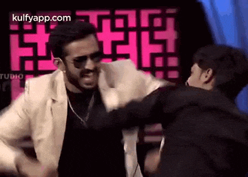 a man in a white jacket and sunglasses is fighting another man in a black jacket .