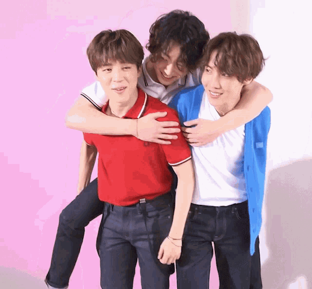 a man in a red shirt is carrying another man on his back