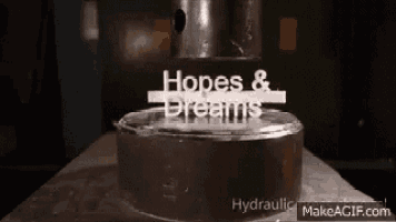 a close up of a metal object being hydraulically pressed against a table .