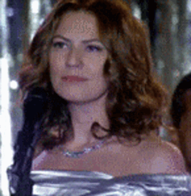 a woman in a pink dress is wrapped in duct tape and looking at the camera .