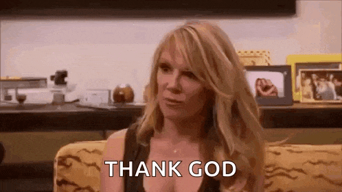 a woman is sitting on a couch with the words `` thank god '' written on the screen .