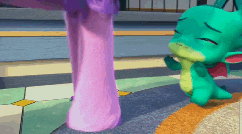 a green dragon with a red wing is sitting on the floor next to a pink leg