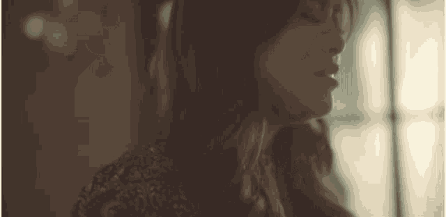 a close up of a woman 's face with her eyes closed and her mouth open .