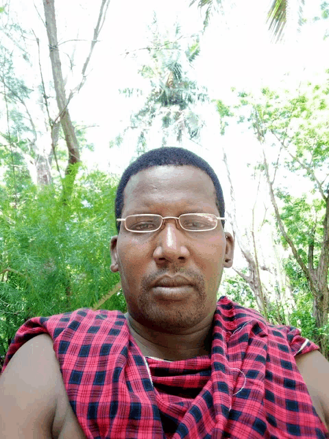 a man with glasses and a plaid scarf around his neck