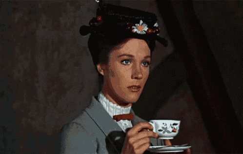 a woman in a hat is drinking from a teacup