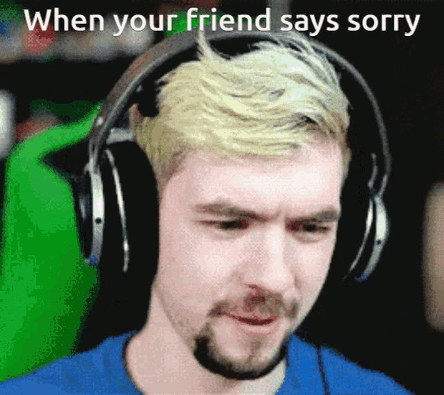 a man wearing headphones with the words when your friend says sorry above him