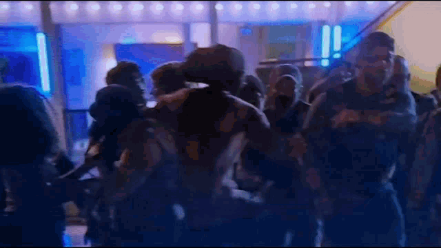 a blurry picture of a crowd of people dancing in a room .