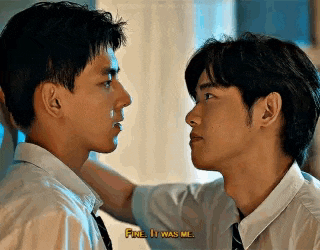 two young men are looking at each other and one of them is holding the other 's arm .