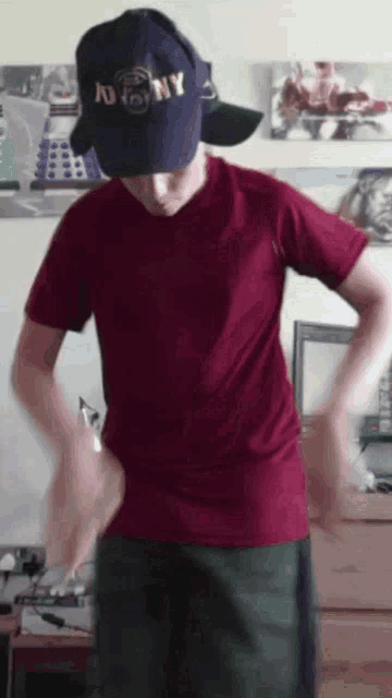 a man wearing a ny hat and a red shirt