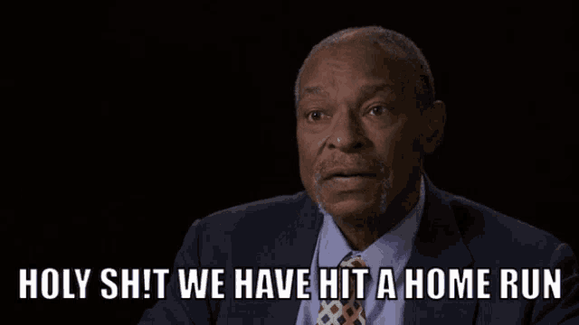 a man in a suit and tie with the words holy shit we have hit a home run