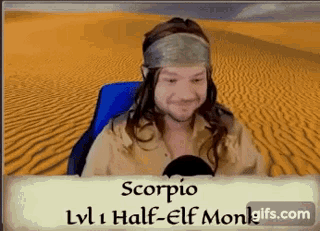 a man with long hair and a bandana on his head is sitting in the desert .