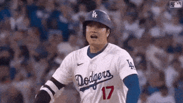 a baseball player wearing a dodgers jersey and helmet is standing on the field .