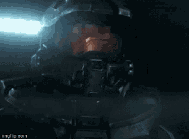 a close up of a man in a helmet holding a gun