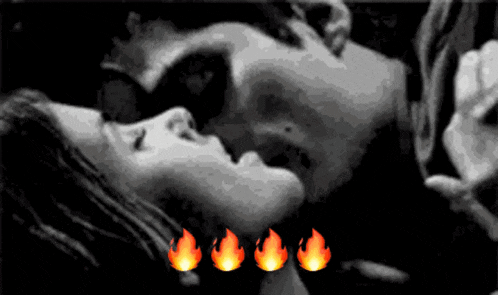 a man and a woman are kissing in a black and white photo with fire icons in the background .