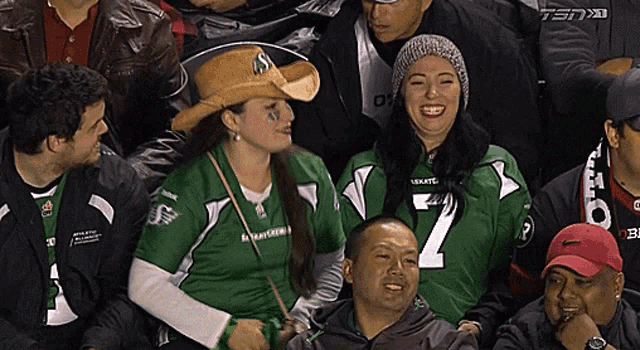 a woman wearing a cowboy hat and a green shirt with the number 7 on it