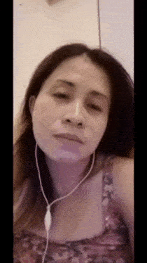 a woman wearing headphones is making a funny face while looking at the camera .
